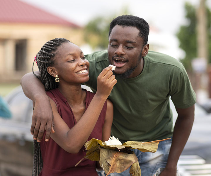 un couple africain qui mange du foutou d'igname dans une feuille de banane.